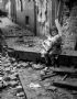 Garotinha e sua boneca sentando nas runas de sua casa bombardeada em 1940 na cidade de Londres