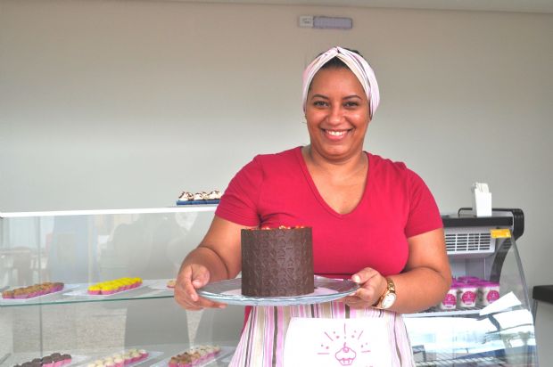 Suelayne e um de seus bolos; No Manac ela vende o pedao por peso. Este  de massa de chocolate, com recheio de brigadeiro de ovomaltine, ganache de chocolate, morangos e mirtilos na decorao.