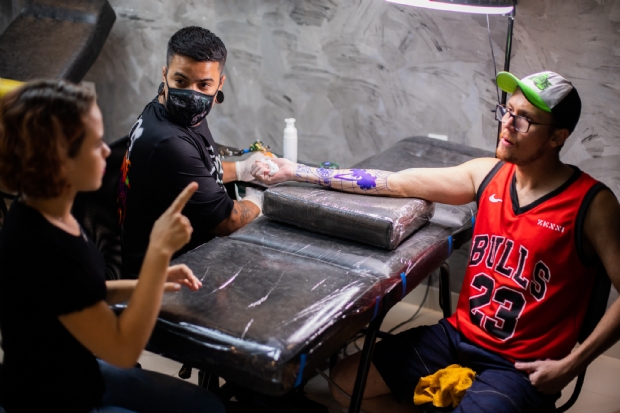 Artista cuiabano conta com ajuda de intérprete de libras para tatuar braço de surdo: 'gratificante'